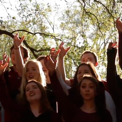 University of South Carolina acapella groups raising their arms for alma mater.