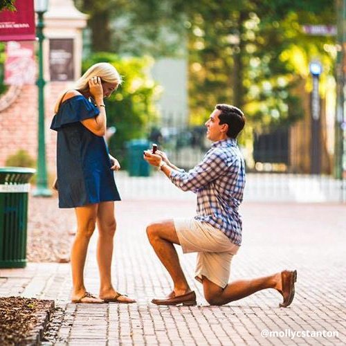 Young man on bended knee proposes to girlfriend on Horseshoe.