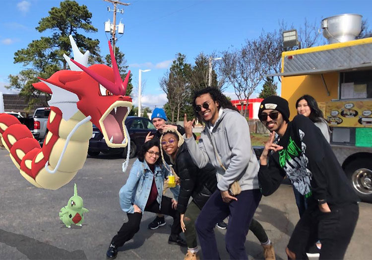Group of students next to Pokemon monsters