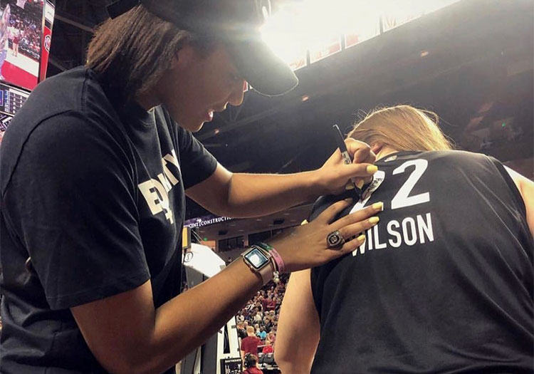 A’ja Wilson signing Rebekah Cloninger’s jersey at basketball game.