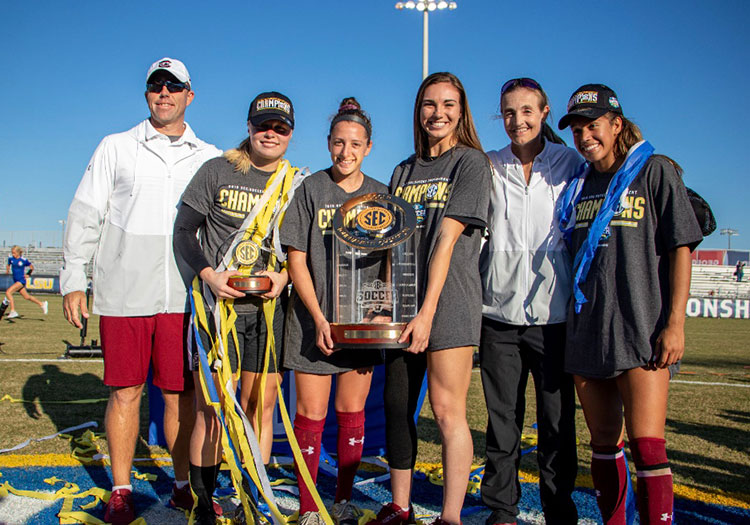 Members and coaches of UofSC Women’s Soccer team holding SEC trophy