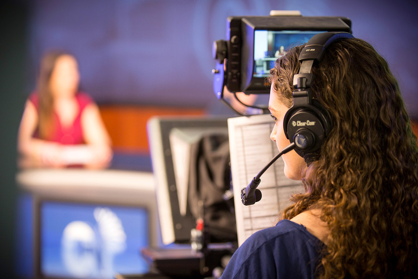 Female student works at a TV station with a headset on.