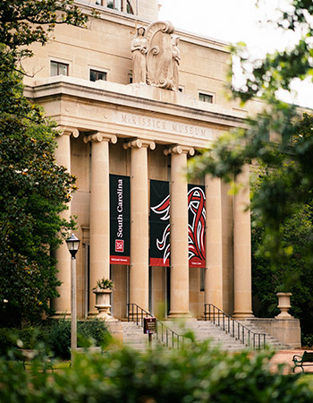 The beautiful McKissick Museum with large columns and banners. 