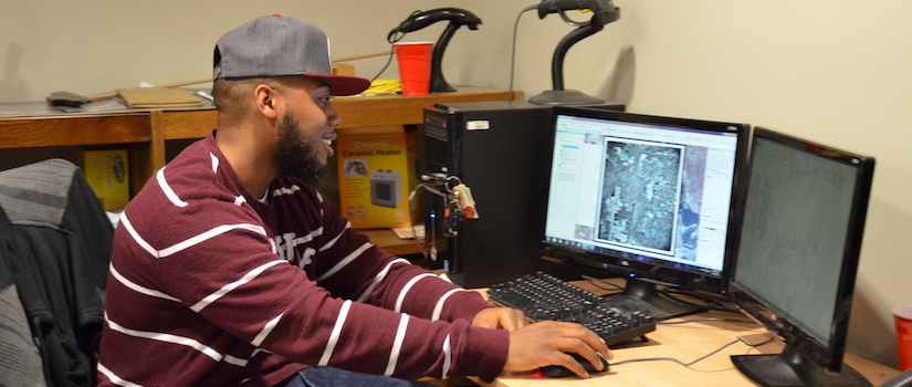 UofSC student examining an aerial image on a computer screen