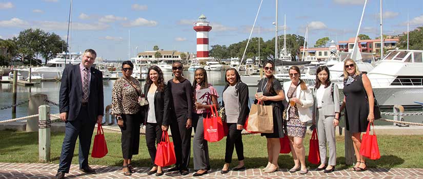 International students pose in Hilton Head's Harbor Town boat basin, a key tourist area for Sea Pines Resort visitors.