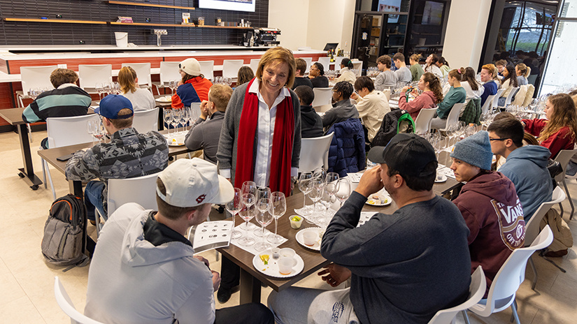Sandy Strick speaks with students during a wine tasting class.