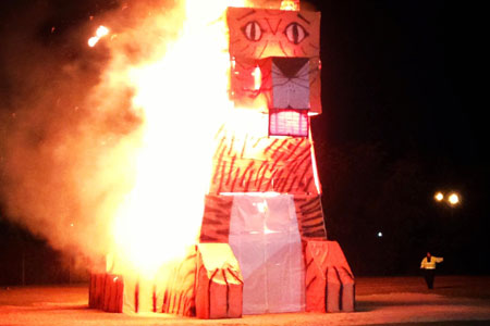 A recent image of the Tiger Burn. This is a large tiger made from a wood frame and paper. It is set ablaze.