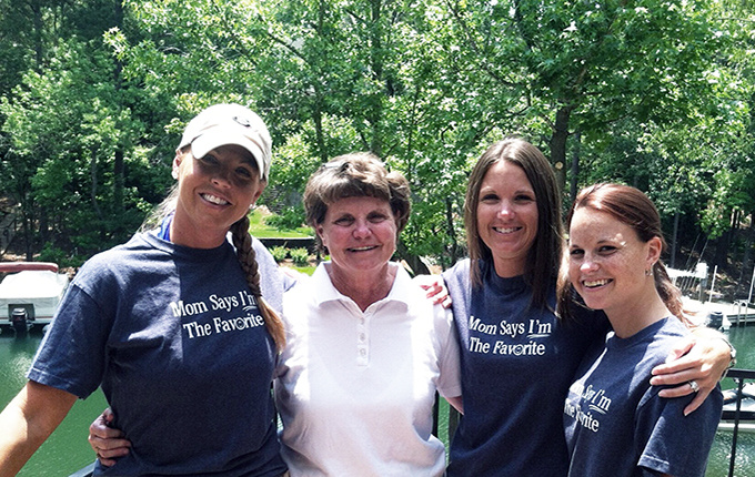 Image of four women smiling with their arms wrapped around each other