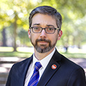 Close up image of a man outside wearing a suit.