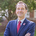 Headshot of Bradley Cole outside in a suit and tie. 