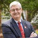 Image of Rob McMahon outside in a suit and tie. 