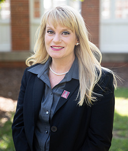 Headshot of Nicole Carrico in a suit outdoors. 