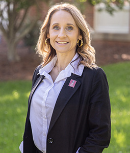 Headshot of Amberly Osteen outdoors in a suit. 