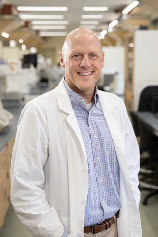 Michael Ryan in a lab coat