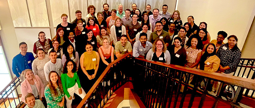 Large group of researchers and students gathered on a staircase for a program photo.