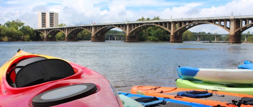 Kayaks on the side of the river beneath the Columbia, South Carolina skyline