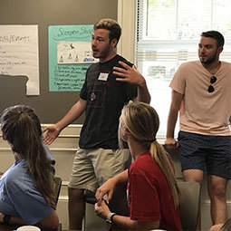 Male student speaks to other students during an interactive business workshop