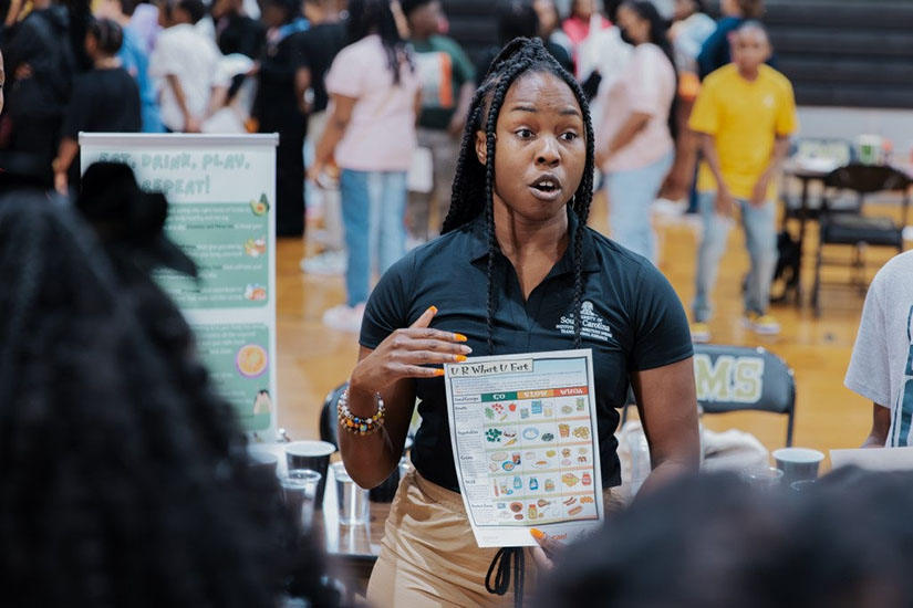 Woman in gymnasium holding informational flyer