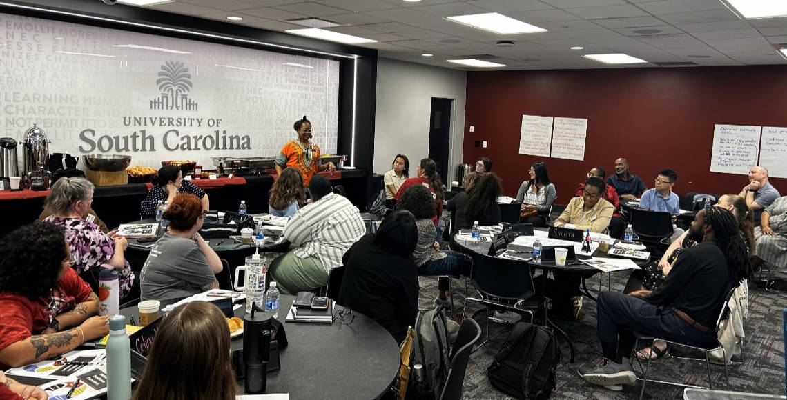 Staff member standing up and talking to a large group.