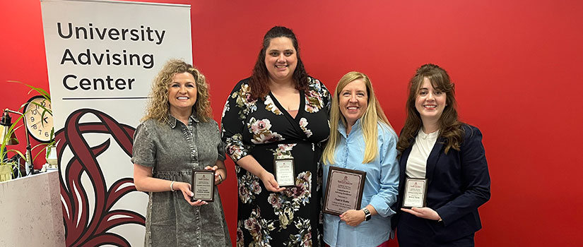 Four advisors are picture holding their award plaque. They are all white women smiling at the camera. 