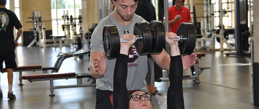 Personal trainer assisting a patron