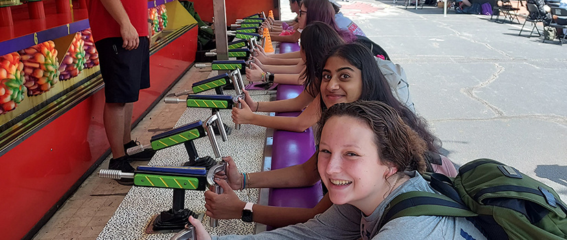 students playing a shooting carnival gamee