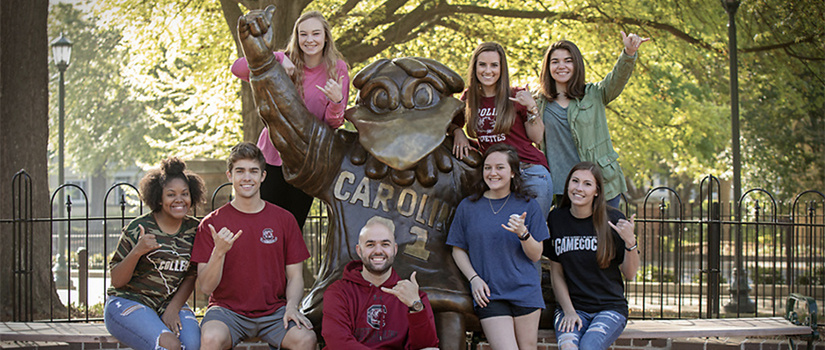 students taking a photo with a Cocky statue