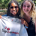 two girls holding a sophomore initiative t-shirt