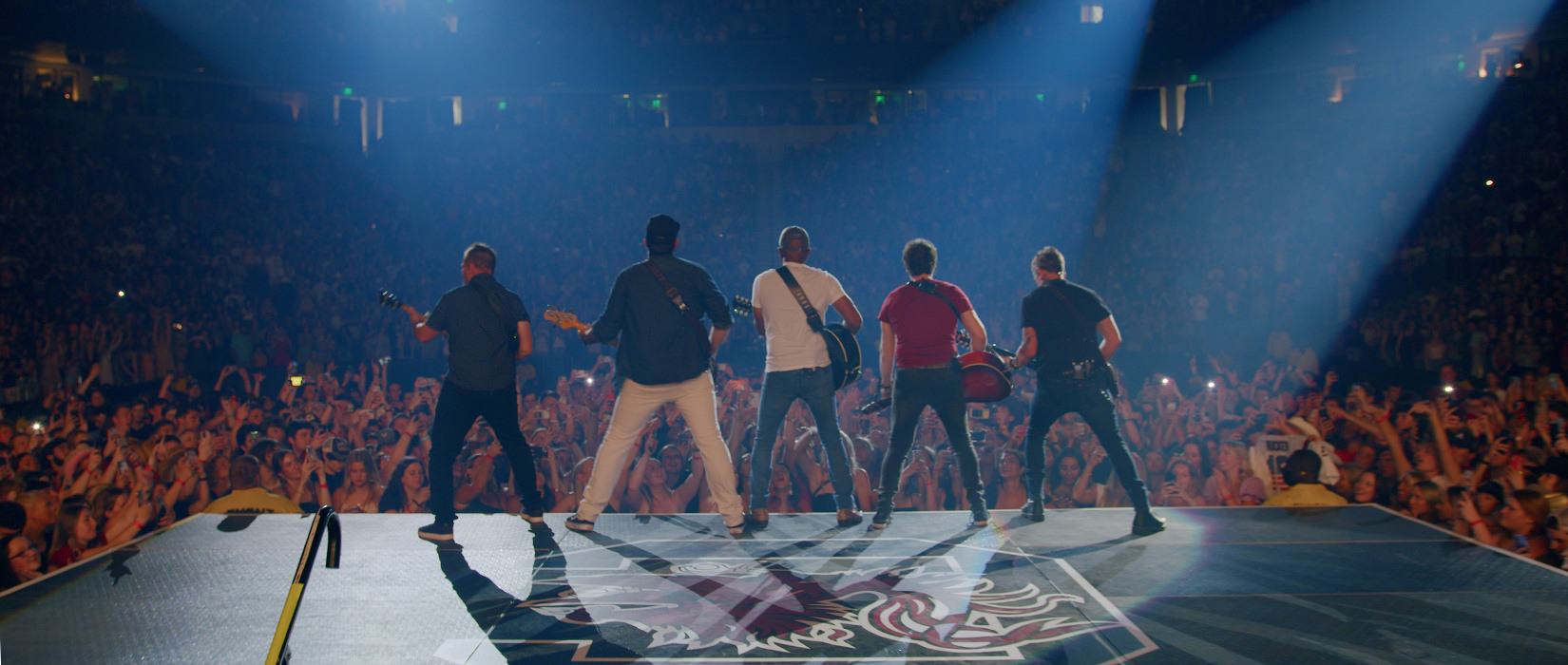 Darius Rucker and bandmates line up on stage, as seen from behind the stage