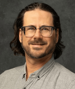 man in gray shirt smiling