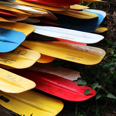 A stack of colorful canoe paddles.