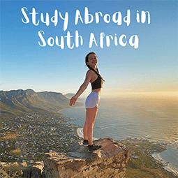 a girl standing on top of a cliff with text that reads study abroad in south africa