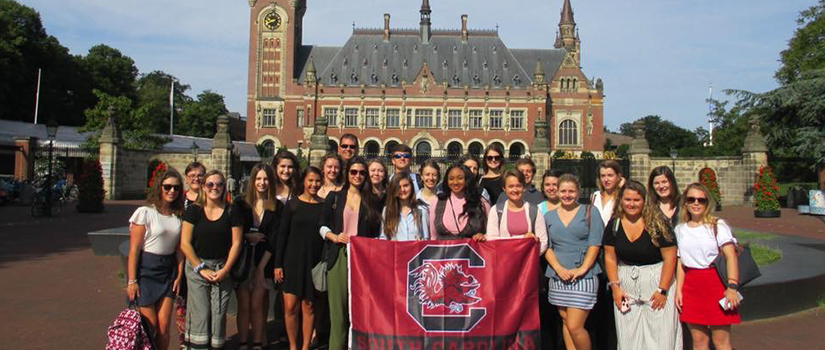 UofSC students in London holding a UofSC flag