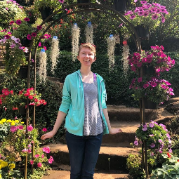 Woman poses in front of a flower display