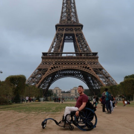 Man in wheelchair in front of the Eiffel Tower in Paris