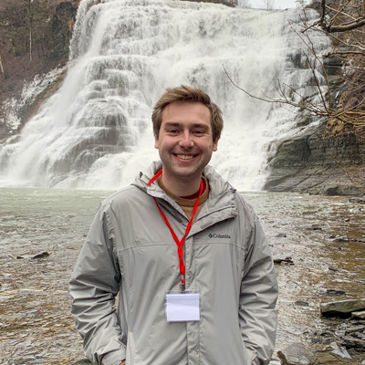 Daniel Coble smiling in front of a waterfall.