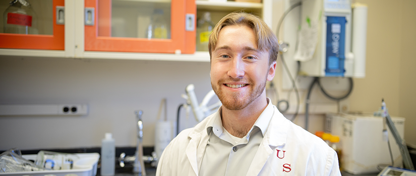 Michael Pitre posing for a photo inside of a science lab