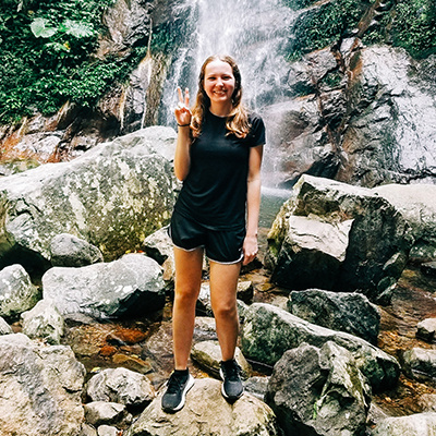 Katie Pakenham stands in front of a waterfall