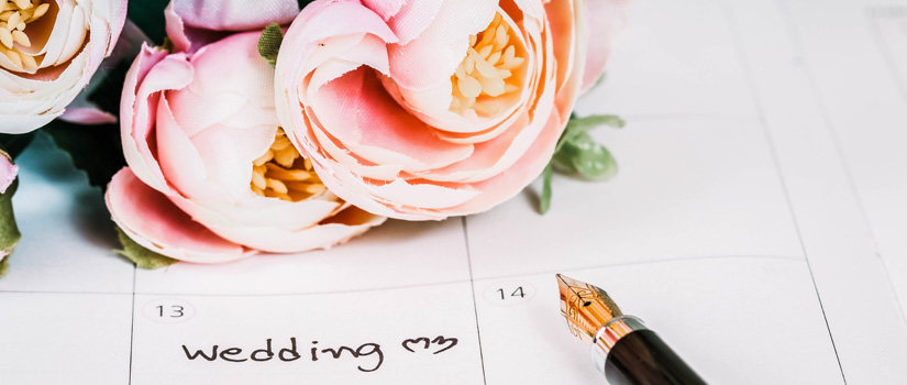 Wedding date circled in a daily planner with accent flowers 