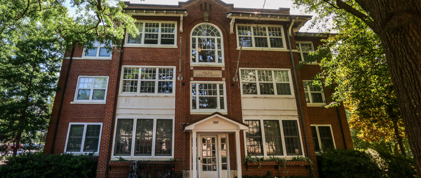 A lower front angle of the brick 820 Henderson Street housing building, showcasing its three stories.