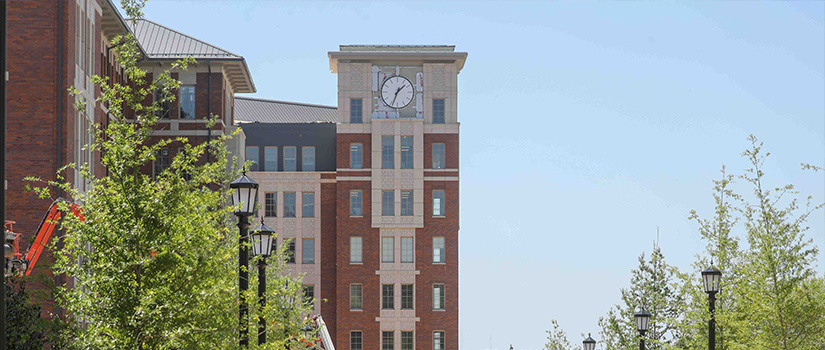 Campus Village building 1 clock tower as seen from the sidewalk beside building 3