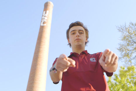 student pointing at you with the USC smoke stack in the background