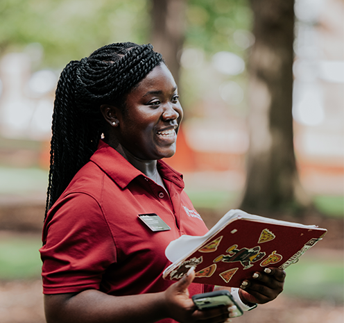 orientation leader outside while holding a clipboard