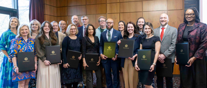 Group photo of the 2026 University of South Carolina Provost award winners standing together in a formal indoor venue, holding award certificates and folders bearing the university seal.