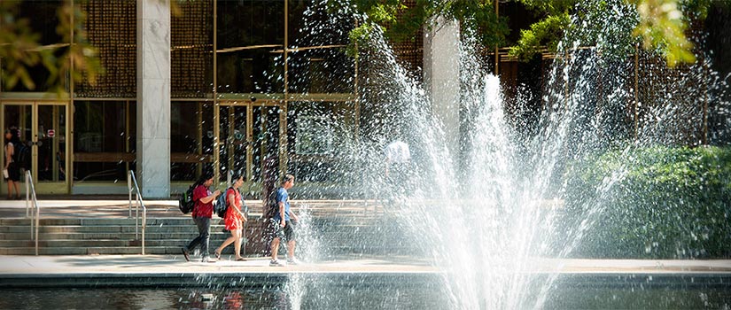 Water fountain sprays while students walk in background