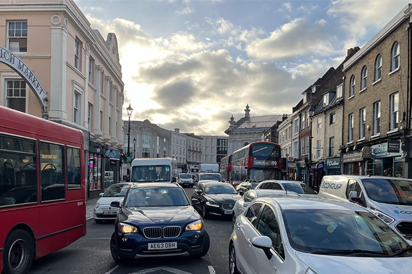 A London street full of cars lined with buildings