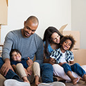 Family of four surrounded by moving boxes