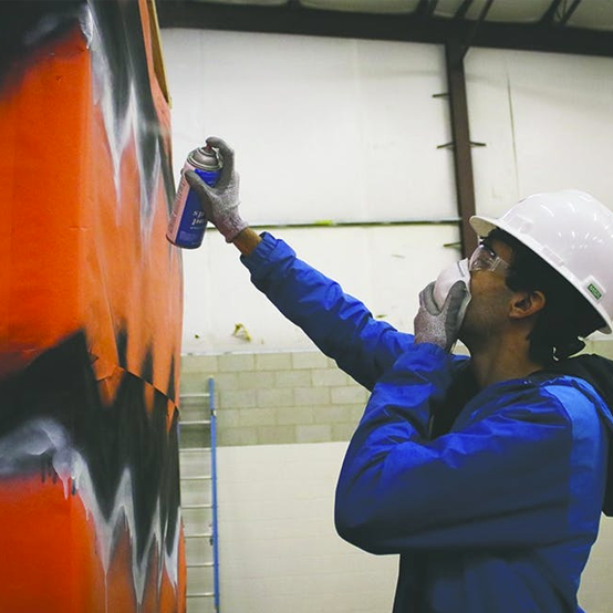 A student spraypainting the fake tiger as it's built.