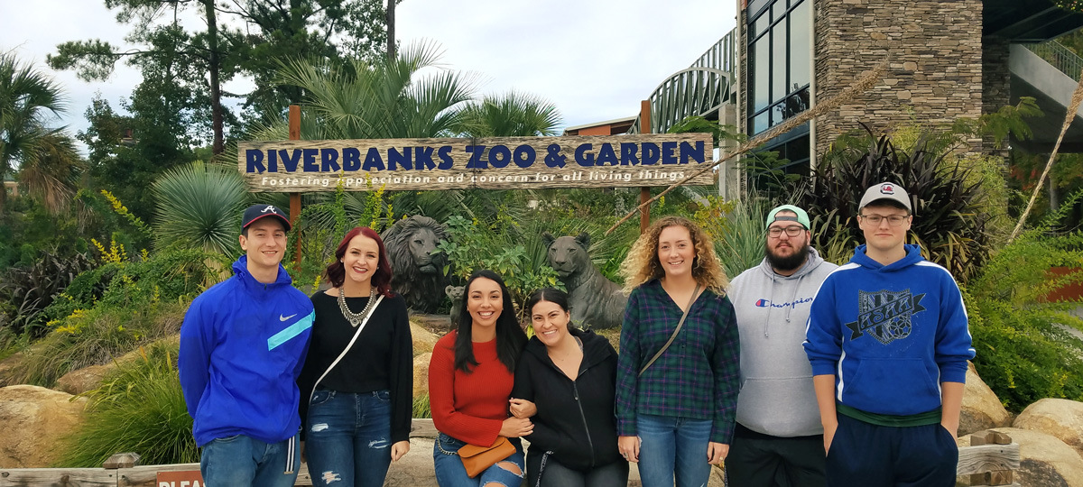 Students posing in front of the Riverbanks Zoo sign