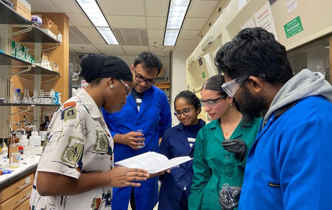a team of undergrads work with their faculty mentor